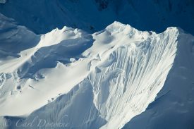 A fresh snowfall covers this fluted, jagged aréte high in the St. Elias Mountain Range. Aerial Photo.